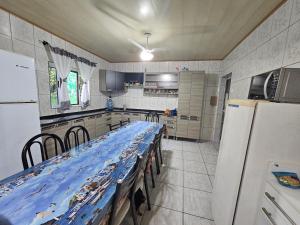 a kitchen with a long table in the middle at Pousada Wisocki in Matinhos