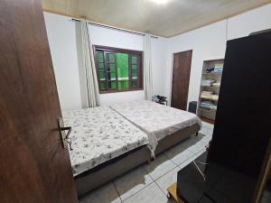 a bedroom with a bed and a window at Pousada Wisocki in Matinhos