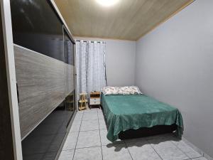 a small bedroom with a bed and a window at Pousada Wisocki in Matinhos