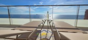 een balkon met een tafel en uitzicht op de oceaan bij Nini Sunset Sailor Luxury Apartment in Benidorm