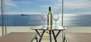een tafel met twee glazen en een fles wijn bij Nini Sunset Sailor Luxury Apartment in Benidorm