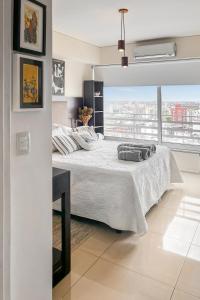 a white bedroom with a bed and a large window at San Telmo Suites 12 in Buenos Aires +20 photos