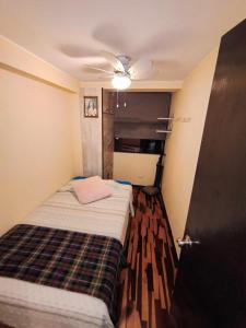 a small room with a bed and a ceiling fan at Apartamento Acogedor, tranquilo y privado in Lima