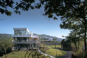 ein Haus auf einem Hügel mit Bergen im Hintergrund in der Unterkunft LOSTVILLA·Green Gable(Anji) in Anji