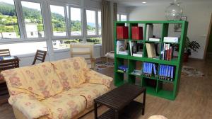 sala de estar con sofá y estantería con libros en El Albergue del Montero, en Mondoñedo