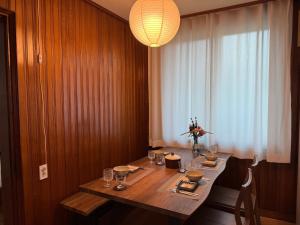 P'aengsŏngSlow Stay, Camp Humphreys的一间带木桌和吊灯的用餐室