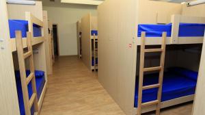 a row of bunk beds in a room with blue beds at El Albergue del Montero in Mondoñedo