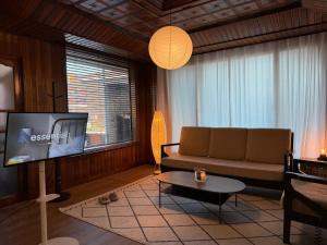 P'aengsŏngSlow Stay, Camp Humphreys的客厅里有一张沙发和一台电视