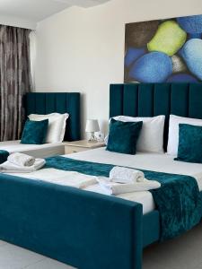 Dos camas en una habitación con azul y blanco. en Hotel Santa Paola, en Sarandë