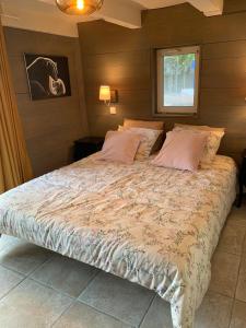 a bedroom with a large bed with pink pillows at L'atelier au jardin in Strasbourg