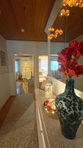 a vase with red flowers on a counter in a kitchen at Peaceful house for relaxing in Oulu