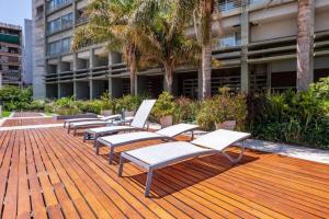 a row of chaise lounges on a wooden deck at San Telmo Suites 12 in Buenos Aires
