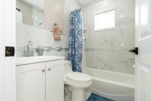 a bathroom with a toilet and a sink and a shower at 558-3 3BR Boston - Modern Nest near Franklin Park in Boston +39 photos