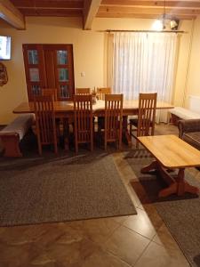 a dining room with a wooden table and chairs at Fenyves Home in Izvoare +18 photos