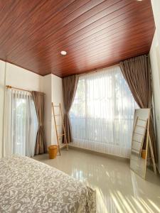 JasriVilla Strelitzia的一间带木质天花板、窗户和床的卧室