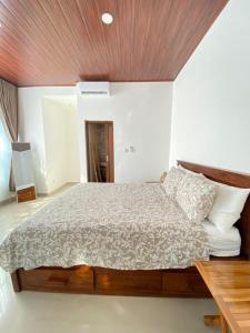 JasriVilla Strelitzia的卧室里有一张大床，配有木质天花板