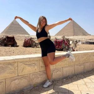 een vrouw op een muur voor de piramiden bij desert Pyramids view inn in Caïro