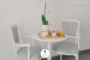 une table et deux chaises avec un plateau de nourriture dessus dans l'établissement Palazzo Chiatamone, à Naples 31 autres photos