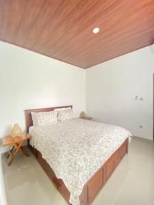 JasriVilla Strelitzia的卧室里有一张大床，配有木质天花板 更多14张照片