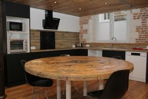Loft industriel - Cambrai hyper centre ville في كامبراي: مطبخ مع طاولة خشبية مع كراسي +10 صور