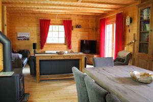 ein Wohnzimmer mit einem Tisch und roten Vorhängen in der Unterkunft John B lodge in Rinken