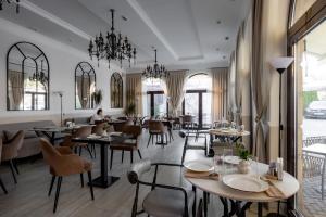a restaurant with tables and chairs and a person in the background at Mountain View Boutique Hotel in Almaty +20 photos