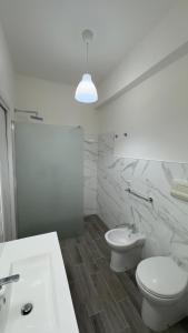 a white bathroom with a toilet and a sink at Casa vacanza Stella in Torre Forte