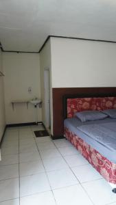 una camera da letto con un letto e un pavimento piastrellato di BROMO B&B a Bromo