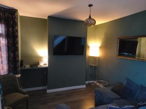 伯明翰Parkdale-Ideal for Birmingham Airport, International Train Station-Resorts World, NEC ,JLR & HS2 sites的配有沙发和平板电视的客厅