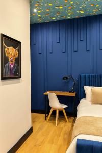 a bedroom with a bed and a desk with a painting of a cow at The Carlton Heights by The HIve WA1 in Warrington