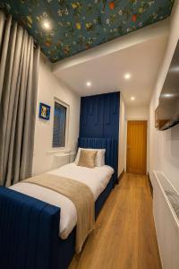 a bedroom with a bed with a blue headboard at The Carlton Heights by The HIve WA1 in Warrington