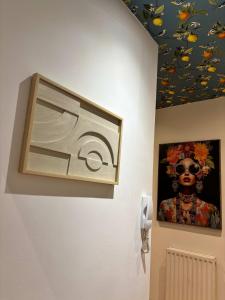 a painting on a wall next to a picture of a woman at The Carlton Heights by The HIve WA1 in Warrington