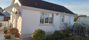 a white house with a black roof at The Garden Suite 3 Star NITB SuperHost in Dungannon +12 photos