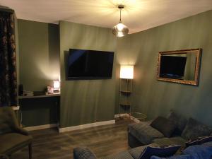 伯明翰Parkdale-Ideal for Birmingham Airport, International Train Station-Resorts World, NEC ,JLR & HS2 sites的配有沙发和平板电视的客厅