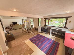 Pousada Hibisco في ترانكوسو: غرفة معيشة كبيرة مع طاولة ومطبخ