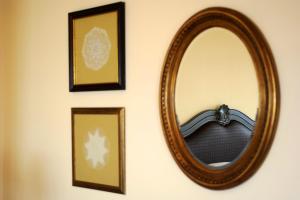 a mirror hanging on a wall with framed pictures at Byblos Sur Mer in Jbeil