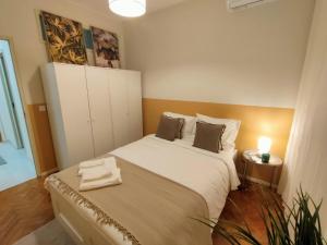 Lovely room in city centre في ليريا: غرفة نوم صغيرة مع سرير وخزانة بيضاء +26 صورة