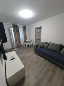 un soggiorno con un divano blu e un tavolo di Apartament 2 camere a Craiova