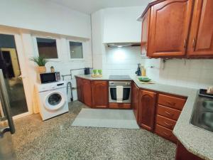Lovely room in city centre في ليريا: مطبخ مع غسالة ملابس وغسالة