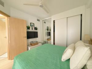 a bedroom with a green bed and a television at Ático Dúplex con Jacuzzi en Vera Playa y parking cubierto enorme in Vera