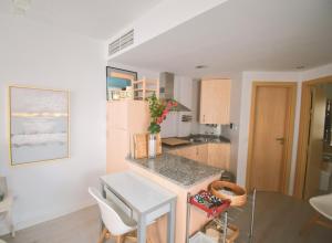 a kitchen with white walls and a table and chairs at Ático Dúplex con Jacuzzi en Vera Playa y parking cubierto enorme in Vera