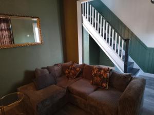 伯明翰Parkdale-Ideal for Birmingham Airport, International Train Station-Resorts World, NEC ,JLR & HS2 sites的客厅设有棕色的沙发和楼梯。 更多38张照片