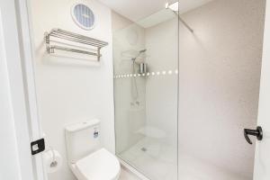 un bagno con wc e doccia in vetro di Eildon Lake Motel a Eildon Altre 15 foto