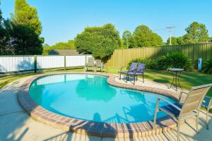 una piccola piscina con sedie e tavolo di Eildon Lake Motel a Eildon