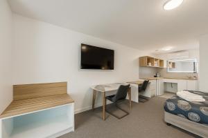 Piccola camera con scrivania, letto e tavolo. di Eildon Lake Motel a Eildon