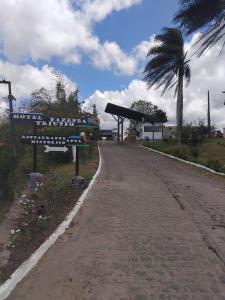 a dirt road with a sign and a palm tree at Hotel Fazenda Triunfo in Areia