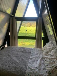 Balsa NovaにあるChalé do Cerro Fazenda Cerro do Purunaの大きな窓のある部屋のベッド