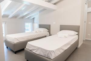 デセンツァーノ・デル・ガルダにあるResidence Il Giglioの白い壁の部屋にベッドが2つある