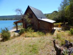 a cabin on the shore of a lake at Cabañas Solo Por Hoy in Villa Pehuenia