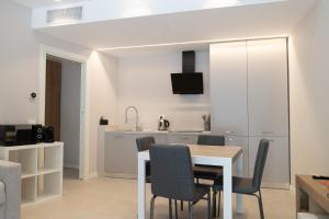 デセンツァーノ・デル・ガルダにあるResidence Il Giglioのテーブルと椅子のあるキッチンとダイニングルーム